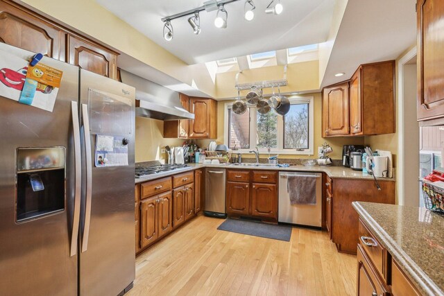 51 Oak Creek Dr, Burr Ridge, IL 60527 - kitchen featuring stainless steel appliances, a skylight, light wood-type flooring, brown cabinets, and a sink
