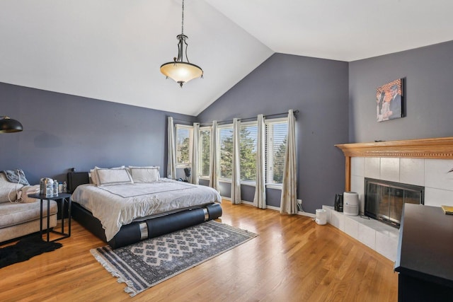 51 Oak Creek Dr, Burr Ridge, IL 60527 - bedroom with high vaulted ceiling, wood finished floors, a tiled fireplace, and baseboards