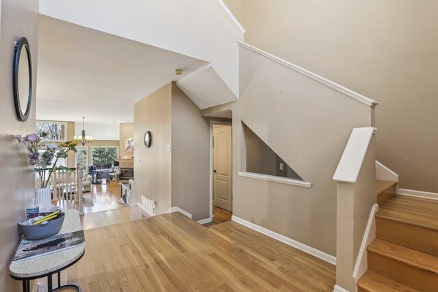 51 Oak Creek Dr, Burr Ridge, IL 60527 - stairway featuring wood finished floors, baseboards, and a chandelier