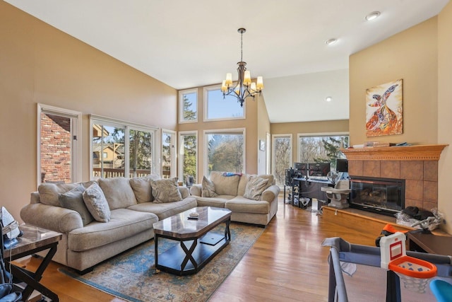 51 Oak Creek Dr, Burr Ridge, IL 60527 - living area with a chandelier, wood finished floors, a tile fireplace, and a towering ceiling