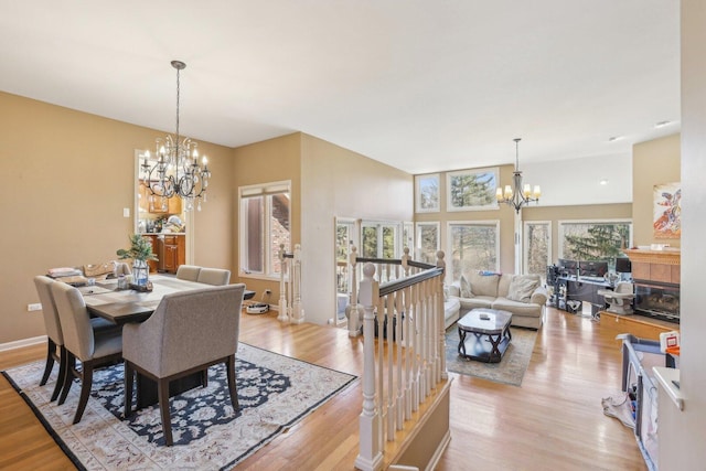 51 Oak Creek Dr, Burr Ridge, IL 60527 - dining area featuring a chandelier, light wood-style flooring, and a tiled fireplace