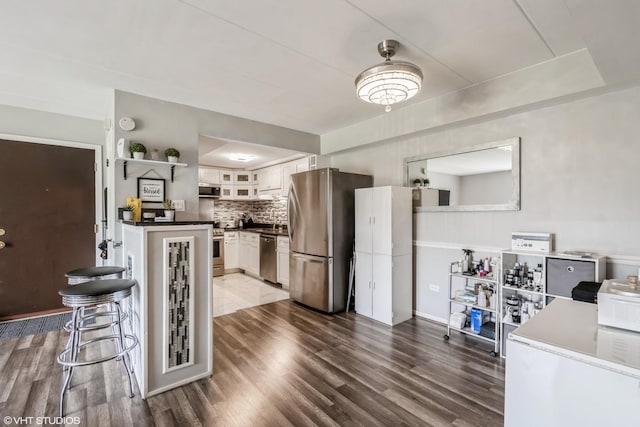 2237 175th St Unit 2A, Lansing, IL 60438 - kitchen with appliances with stainless steel finishes, dark countertops, dark wood-style floors, white cabinetry, and glass insert cabinets