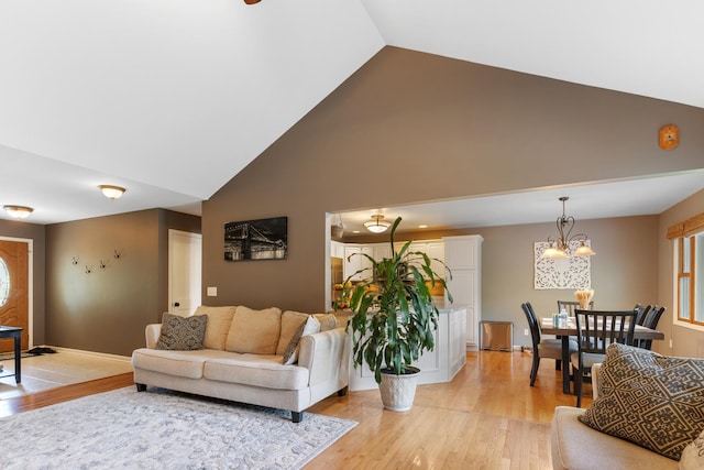 807 Meadow Ln, North Aurora, IL 60542 - living room with high vaulted ceiling, light wood finished floors, a chandelier, and baseboards
