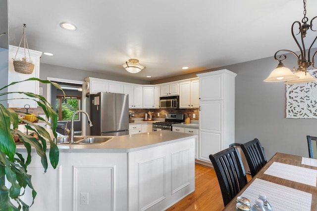 807 Meadow Ln, North Aurora, IL 60542 - kitchen with appliances with stainless steel finishes, a sink, light countertops, decorative backsplash, and white cabinets