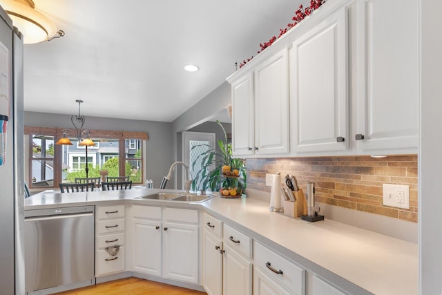 807 Meadow Ln, North Aurora, IL 60542 - kitchen featuring stainless steel dishwasher, a sink, tasteful backsplash, a peninsula, and white cabinets