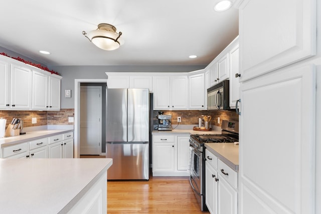 807 Meadow Ln, North Aurora, IL 60542 - kitchen with appliances with stainless steel finishes, backsplash, white cabinets, and recessed lighting