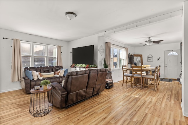living room featuring light wood-style flooring, a ceiling fan, and baseboards