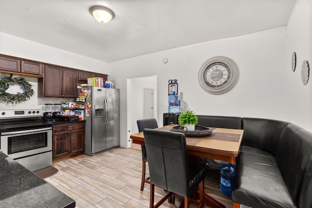kitchen with appliances with stainless steel finishes, dark brown cabinets, and dark countertops