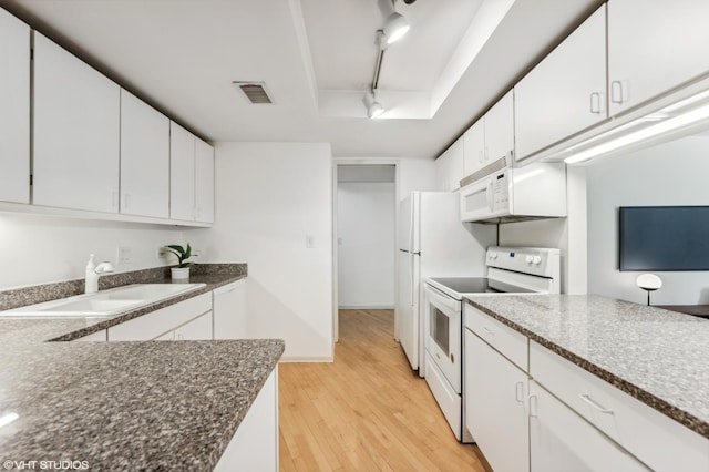 40 E Delaware Pl Unit 301, Chicago, IL 60611 - kitchen featuring white appliances, rail lighting, a sink, light wood finished floors, and white cabinets
