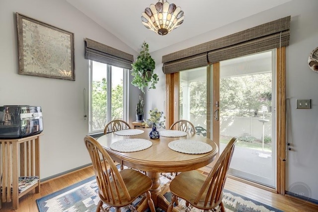dining space featuring lofted ceiling, plenty of natural light, and light wood-style floors
