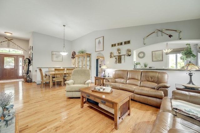 living room with light wood-type flooring and vaulted ceiling