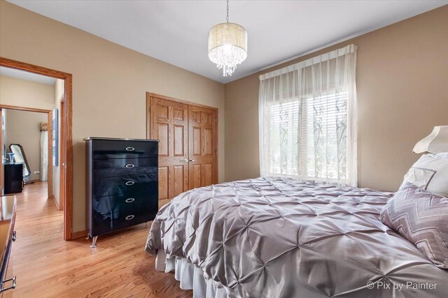 1122 Souders Ave, Elburn, IL 60119 - bedroom with light wood-style flooring, a closet, and a chandelier