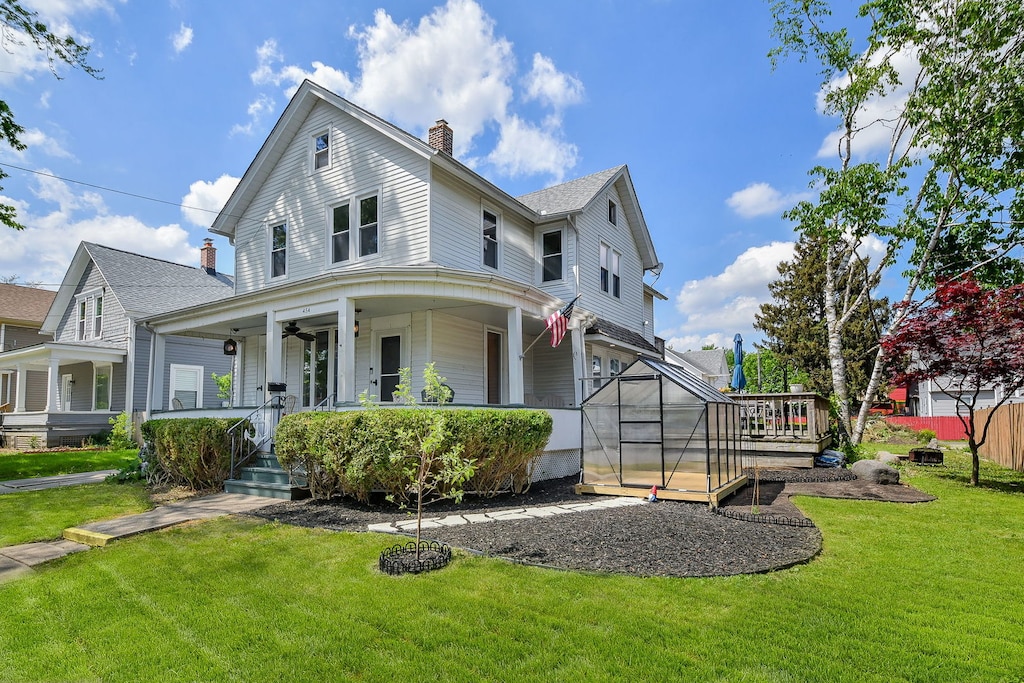454 Weston Ave, Aurora, IL 60505 - view of front facade featuring covered porch, a chimney, a front lawn, and a greenhouse