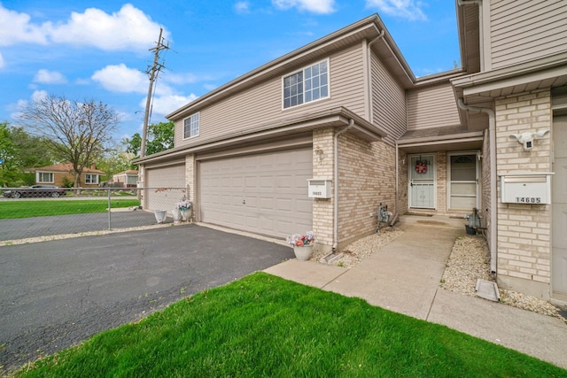 14603 Maple Ln, Dolton, IL 60419 - view of side of property with a garage, asphalt driveway, brick siding, and fence