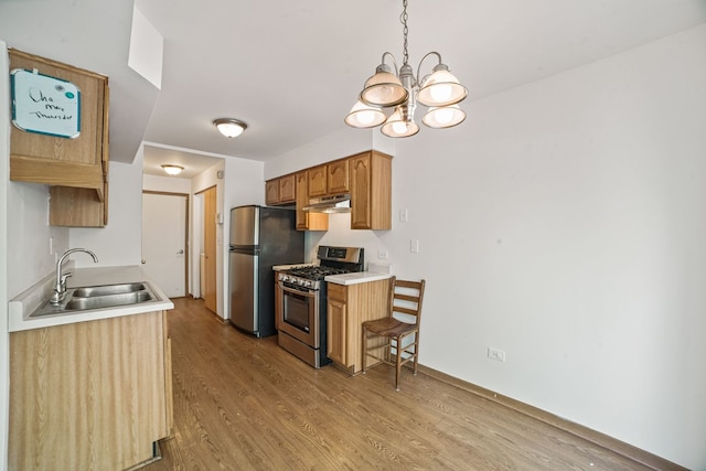 14603 Maple Ln, Dolton, IL 60419 - kitchen with stainless steel appliances, a sink, under cabinet range hood, light wood-type flooring, and a chandelier