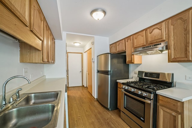 14603 Maple Ln, Dolton, IL 60419 - kitchen featuring stainless steel appliances, under cabinet range hood, a sink, light wood-style flooring, and light countertops