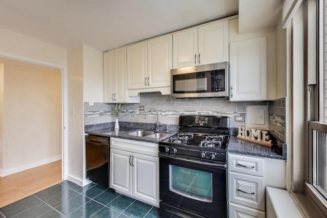 kitchen featuring black appliances, a sink, white cabinets, and tasteful backsplash