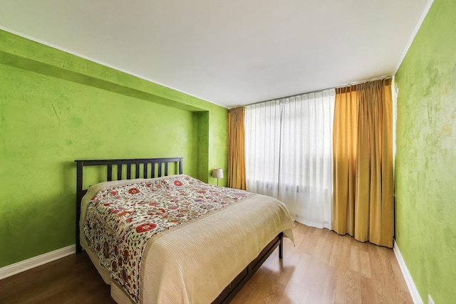 bedroom with wood finished floors and baseboards