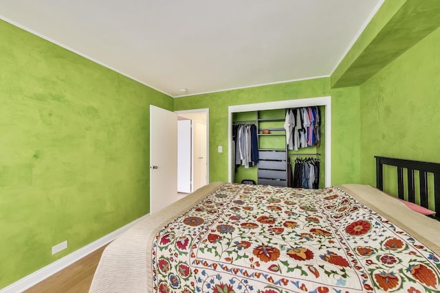 bedroom featuring wood finished floors, a closet, and baseboards