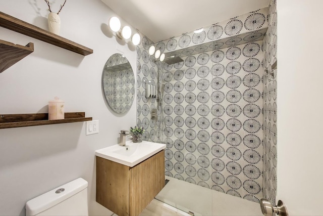 bathroom featuring toilet, a shower, and vanity