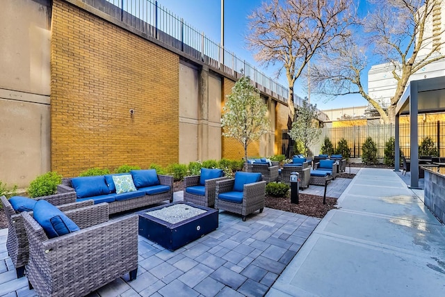view of patio / terrace with an outdoor living space with a fire pit and fence