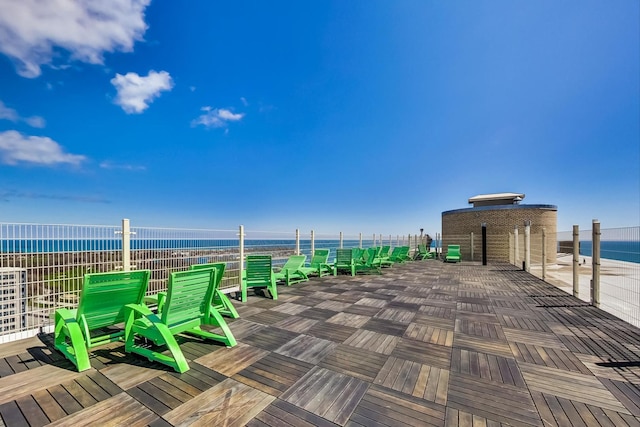 view of patio / terrace featuring a water view and fence