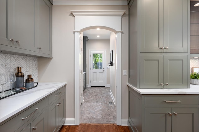 kitchen featuring gray cabinetry, arched walkways, and baseboards