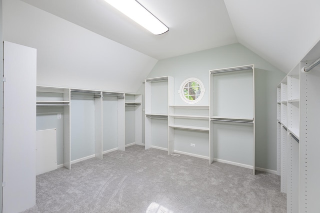 walk in closet with carpet floors and lofted ceiling