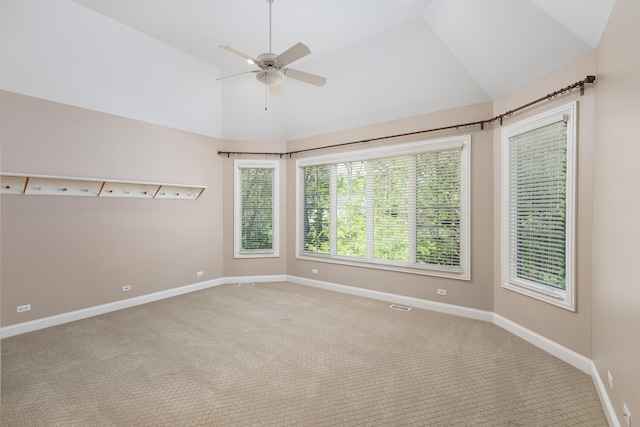 carpeted empty room with vaulted ceiling, ceiling fan, and baseboards