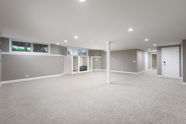 below grade area featuring recessed lighting, baseboards, and light carpet