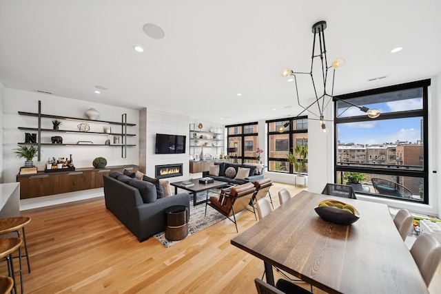 1156 W Ohio St Unit 4E, Chicago, IL 60642 - living area with plenty of natural light, light wood-type flooring, a fireplace, recessed lighting, and a wall of windows