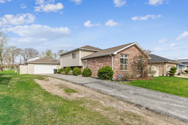 tri-level home featuring brick siding, a front yard, a garage, and a shingled roof