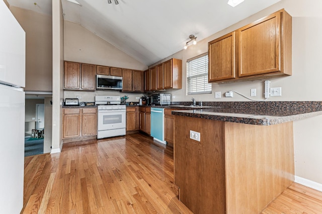 kitchen with white gas range oven, stainless steel microwave, dishwashing machine, light wood-style floors, and a peninsula