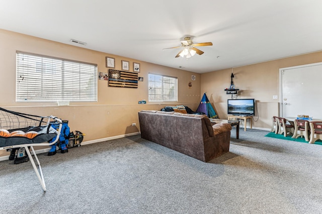 carpeted living room featuring a ceiling fan and baseboards