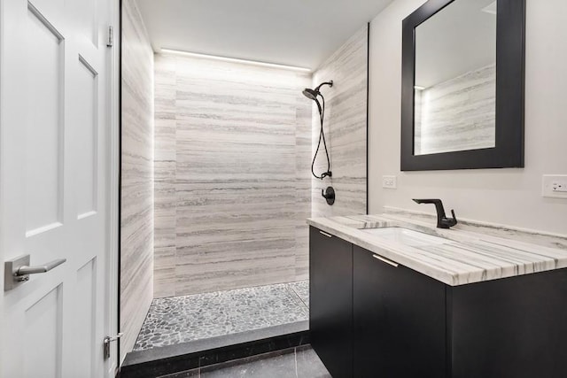 bathroom featuring a tile shower and vanity