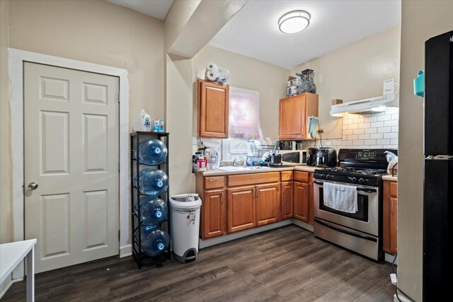 6508 S Albany Ave, Chicago, IL 60629 - kitchen with gas range, white microwave, under cabinet range hood, a sink, and tasteful backsplash