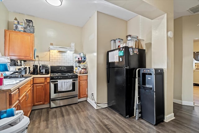 6508 S Albany Ave, Chicago, IL 60629 - kitchen featuring stainless steel gas stove, freestanding refrigerator, dark wood-type flooring, extractor fan, and light countertops