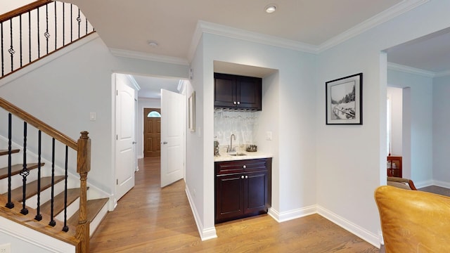 2030 N Oak Wood Dr, Arlington Heights, IL 60004 - indoor wet bar with light wood finished floors, stairs, backsplash, crown molding, and baseboards