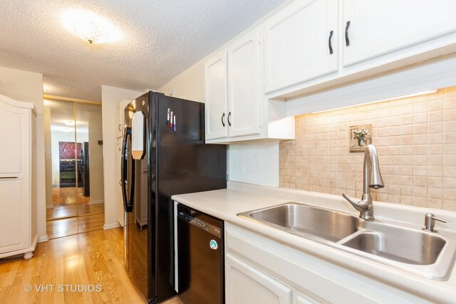 2211 S Highland Ave Unit 4B, Lombard, IL 60148 - kitchen featuring black dishwasher, white cabinets, light countertops, backsplash, and light wood-style flooring