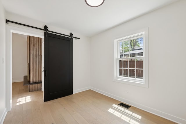1929 S Ashland Ave, Park Ridge, IL 60068 - spare room with a barn door, baseboards, and light wood-style flooring