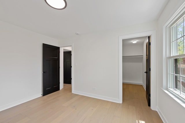 1929 S Ashland Ave, Park Ridge, IL 60068 - unfurnished bedroom featuring a walk in closet, light wood finished floors, baseboards, and a closet