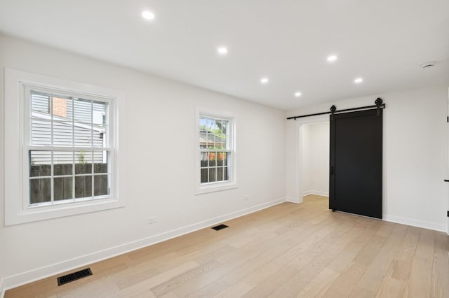 1929 S Ashland Ave, Park Ridge, IL 60068 - unfurnished bedroom with a barn door, light wood-type flooring, baseboards, and recessed lighting