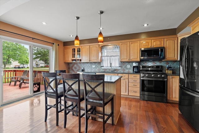 638 E Princeton Ct, Round Lake Beach, IL 60073 - kitchen with appliances with stainless steel finishes, dark wood-style flooring, a kitchen bar, tasteful backsplash, and glass insert cabinets