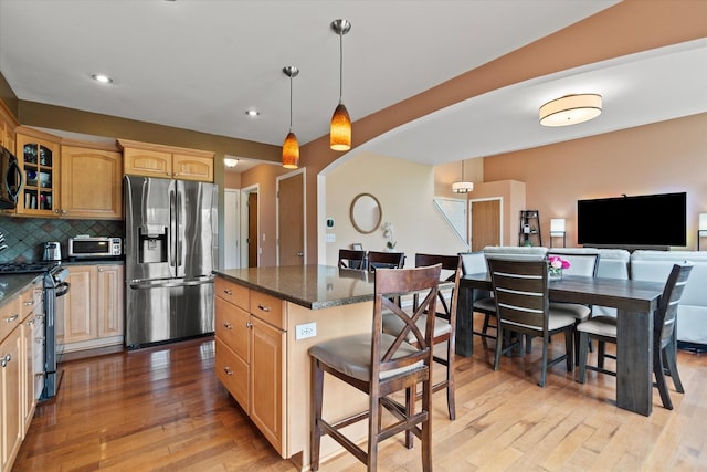 638 E Princeton Ct, Round Lake Beach, IL 60073 - kitchen featuring appliances with stainless steel finishes, light wood-type flooring, glass insert cabinets, a breakfast bar, and a center island