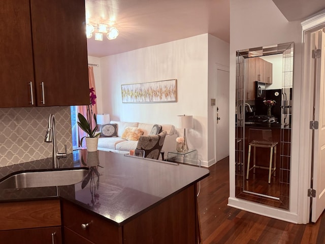 4722 N Beacon St Unit 1E, Chicago, IL 60640 - kitchen featuring a sink, dark countertops, dark wood-type flooring, a peninsula, and tasteful backsplash