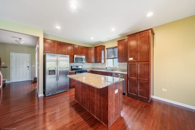 3471 Birch Ln, Naperville, IL 60564 - kitchen featuring appliances with stainless steel finishes, dark wood finished floors, a kitchen island, light stone countertops, and recessed lighting
