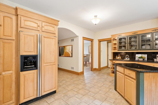 557 Signal Hill Rd, North Barrington, IL 60010 - kitchen featuring light brown cabinets, arched walkways, paneled fridge, and dark stone counters