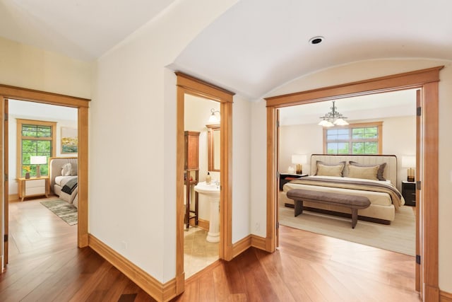 557 Signal Hill Rd, North Barrington, IL 60010 - bedroom featuring a chandelier, hardwood / wood-style flooring, baseboards, ensuite bath, and vaulted ceiling