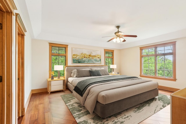 557 Signal Hill Rd, North Barrington, IL 60010 - bedroom with light wood-type flooring, a raised ceiling, baseboards, and ceiling fan