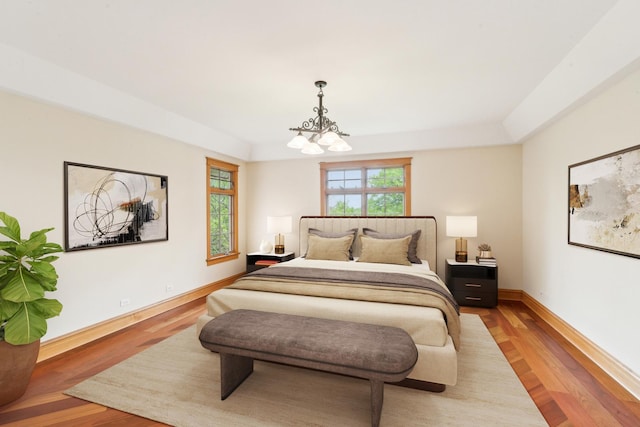 557 Signal Hill Rd, North Barrington, IL 60010 - bedroom with a chandelier, light wood-style flooring, baseboards, and a tray ceiling